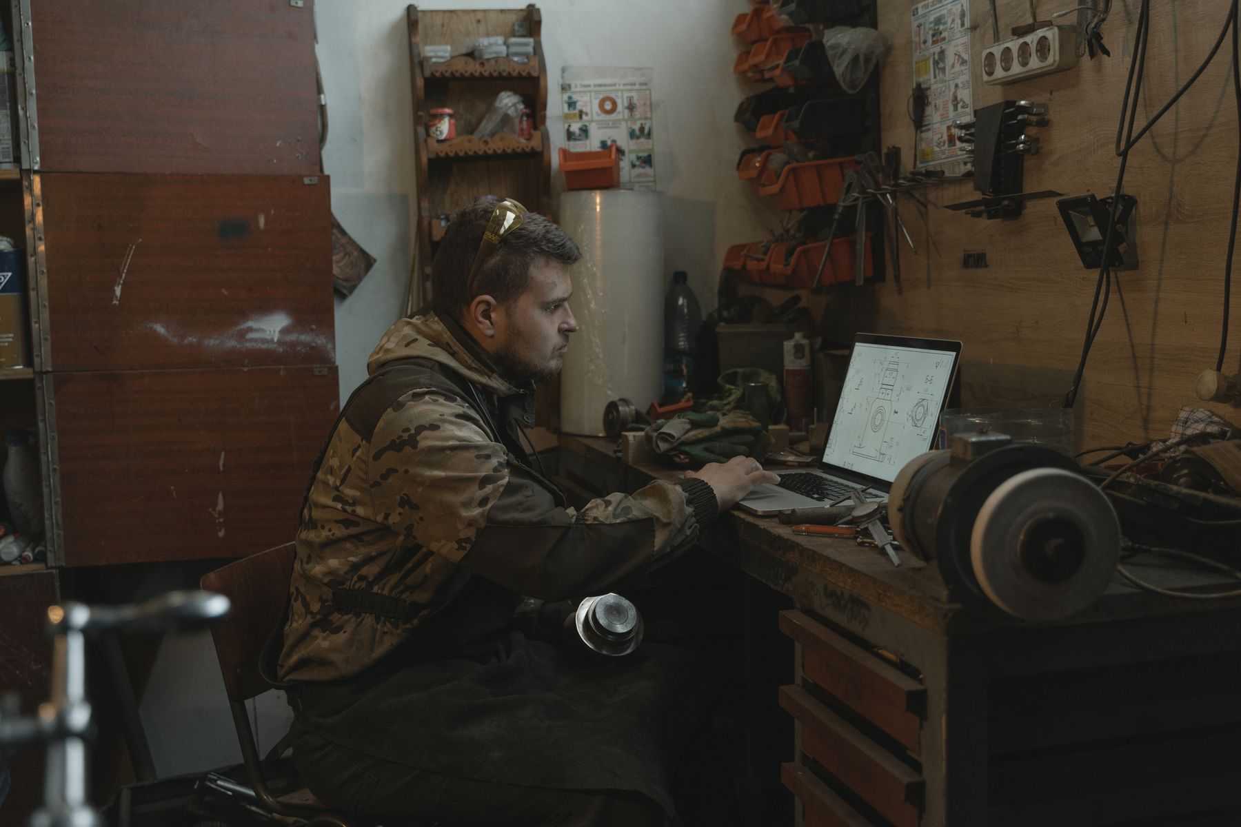 A small business owner using technology while focused on practical work.
